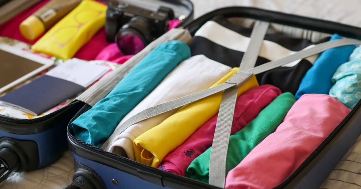 <img src="jak-spakować-walizkę"alt="walkizka z kolorowymi ubraniami">